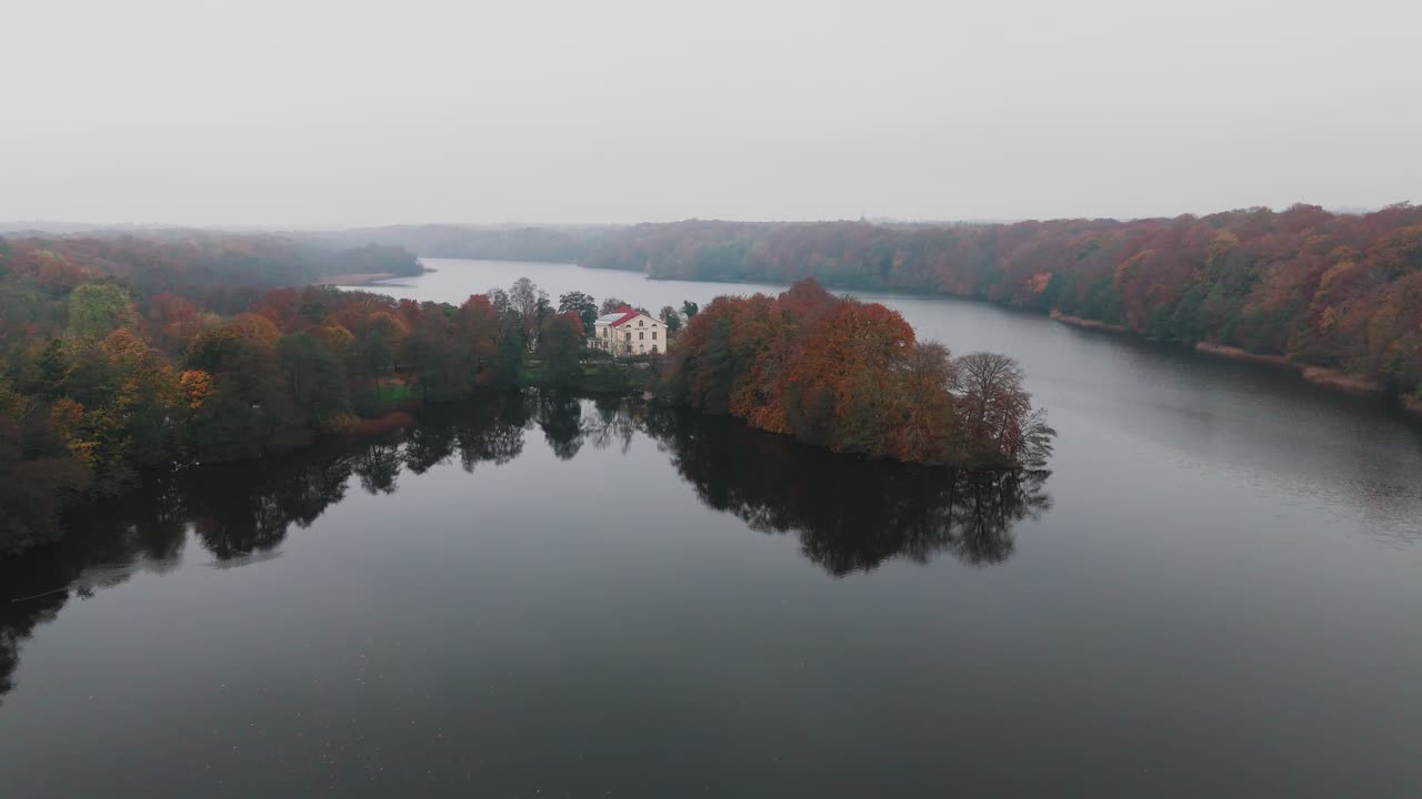 Gyllebo lake in South Sweden, Skåne, Österlen at Autumn with yellow and orange leafs, mansion, fog