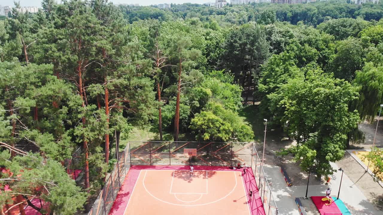 Black young man plays basketball on playground in the park
