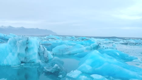 Vista-Aérea-Hacia-Adelante-De-Bloques-De-Hielo-Flotando-En-El-Lago