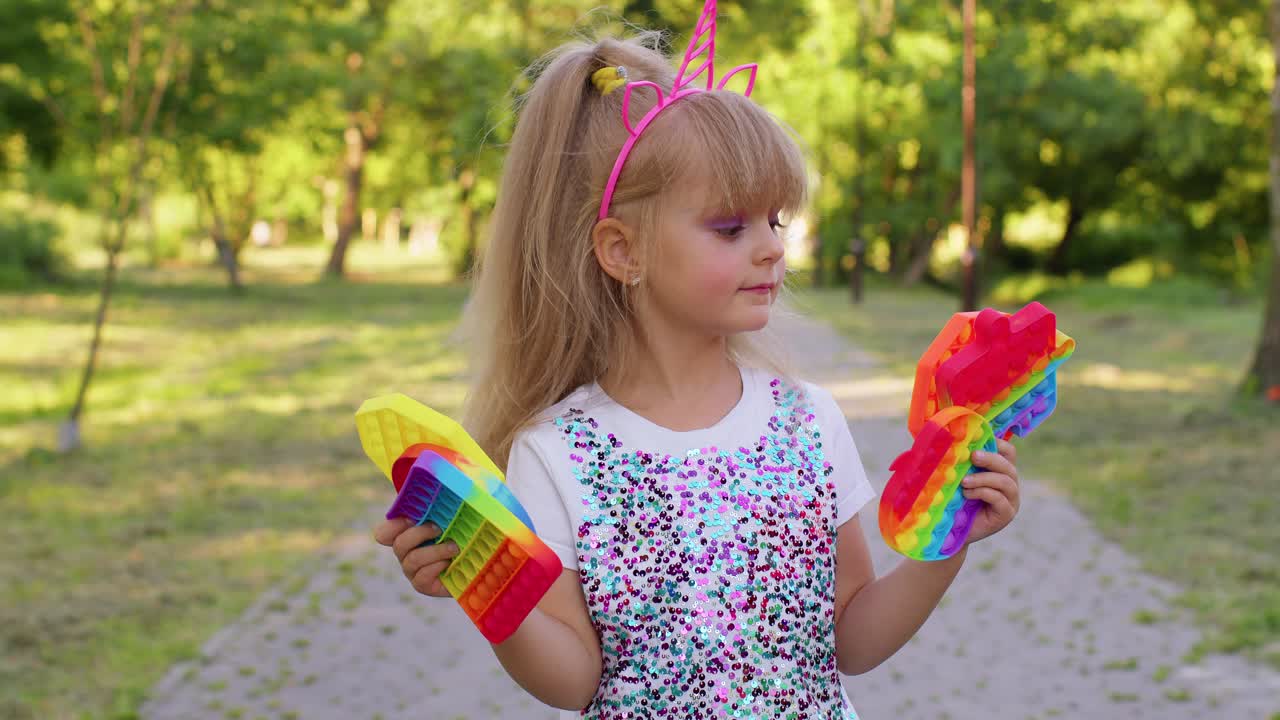 niños niña niño sosteniendo pop it juguete sensorial, de moda inquietante juego de burbujas de silicona contra el estrés