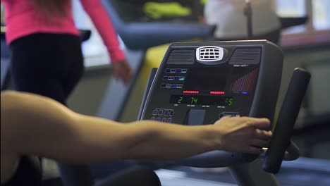 mujer trabajando en una máquina de remo en un gimnasio
