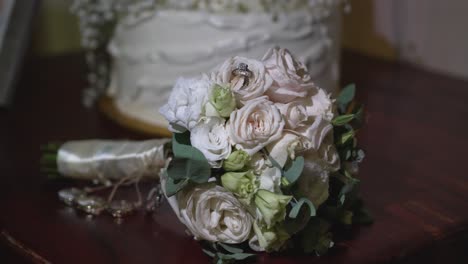 shiny white gold wedding rings among the rose petals of the bride's bouquet