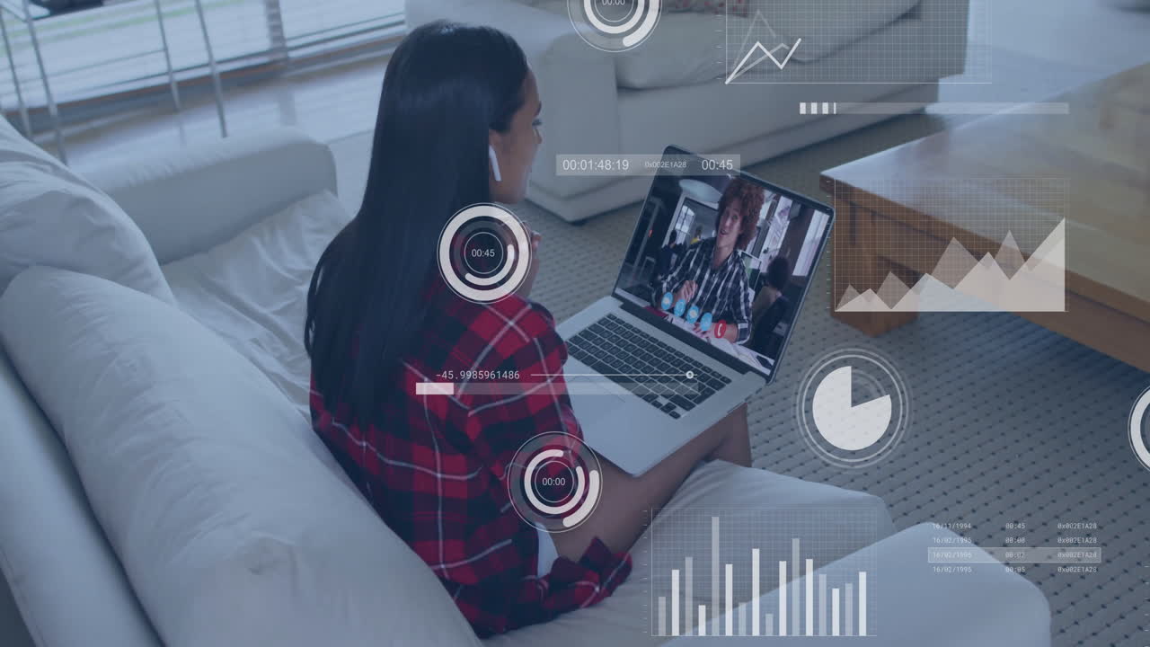 Watching animation with data analytics overlay, woman using laptop in living room