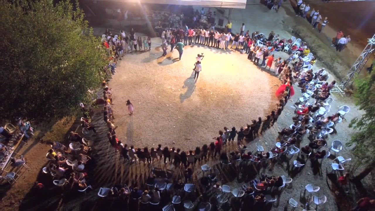 Large Group of People Dancing in a Circle at Night