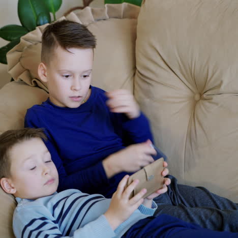 preschool boys playing on smartphone. peaceful pastime. technology and lifestyle concept