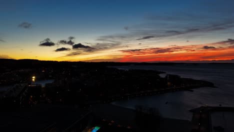 american town on coast of ocean during golden sunset. lighting cityscape with port in america. aerial wide shot.
