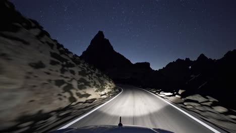 a nighttime road trip video captures a car's perspective, headlights illuminating a winding mountain