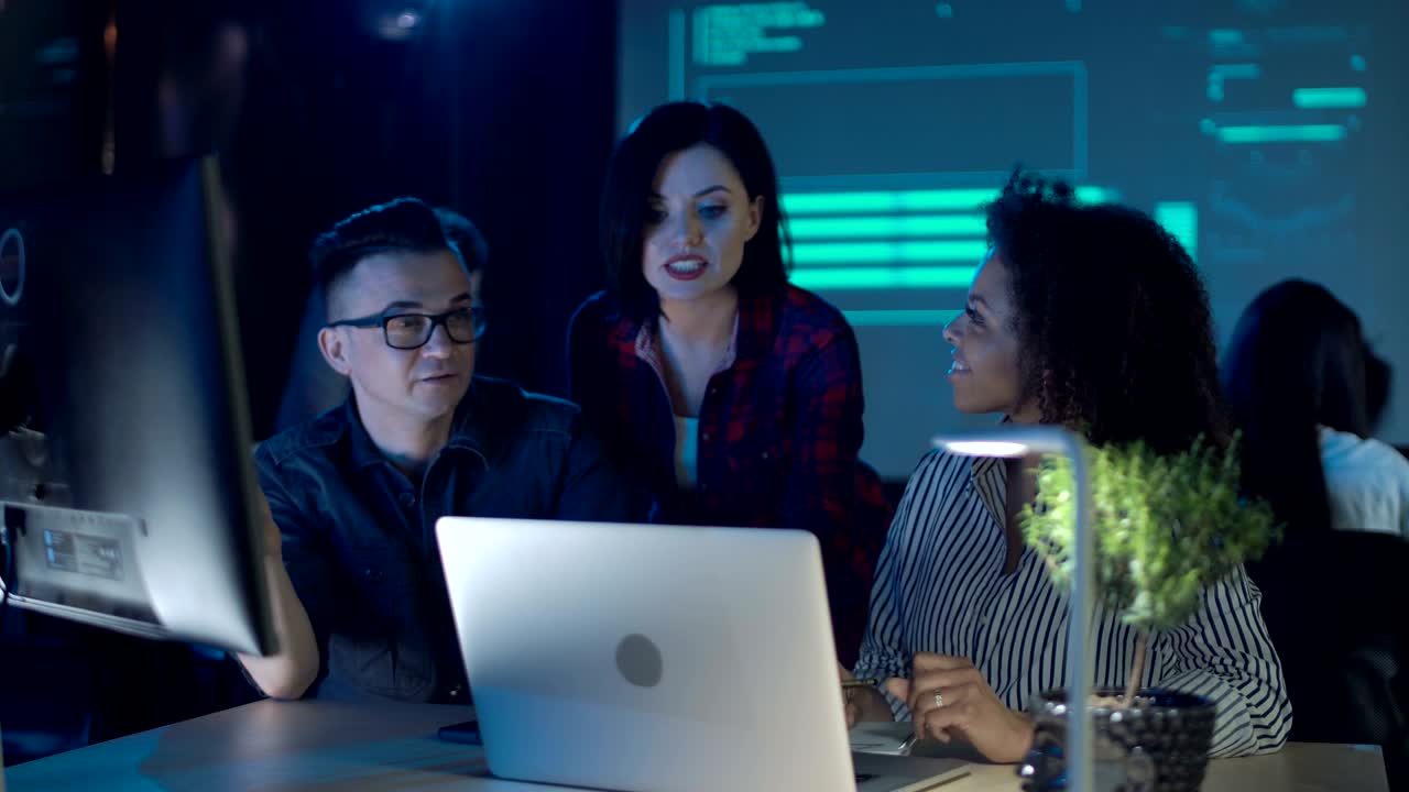 Office workers cooperating at laptop