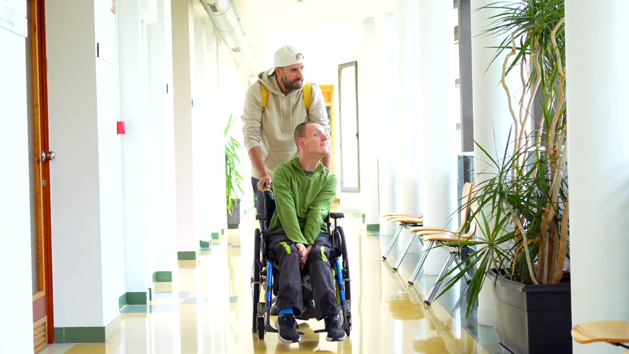 Man assisting a disabled friend in a wheelchair