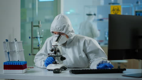 biólogo médico en camiseta comprobando la muestra de adn en el microscopio