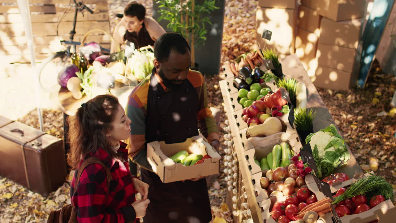 People shopping for produce at an outdoor market stall