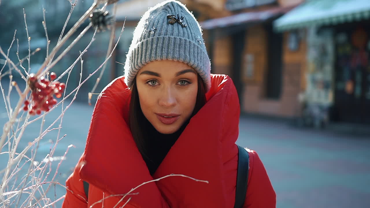 A woman in a red coat and beanie