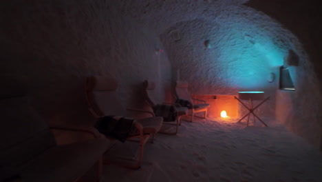 dim lit interior of salt cave with chairs and salt lamp