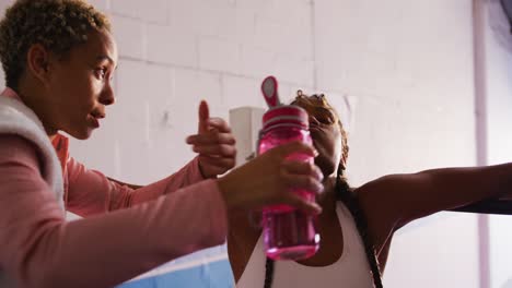 mujeres de raza mixta dando agua a atletas de raza mixta