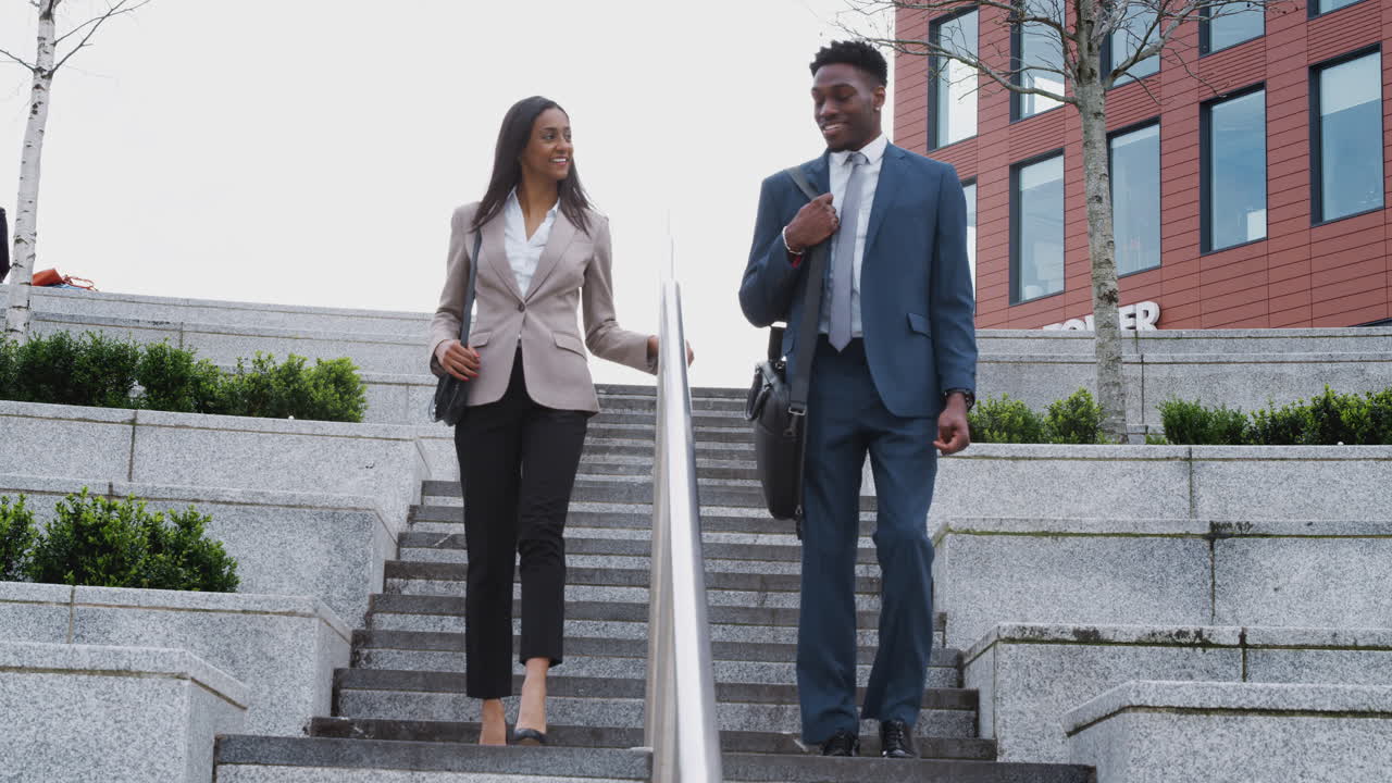 hombre de negocios y mujer de negocios viajando al trabajo caminando por las escaleras fuera del edificio de oficinas
