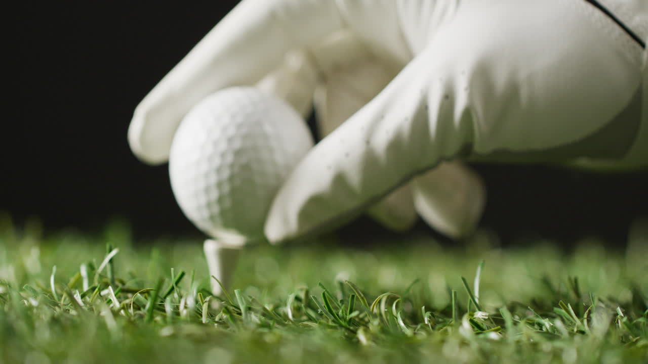 잔디와 검은 바탕에 골프 공을 들고 있는 장갑으로 손을  ⁇ 고, 복사 공간, 슬로우 모션