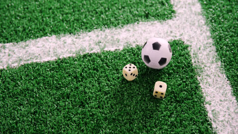 Football-and-dice-on-artificial-grass-4k