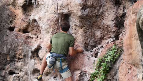 un escalador escalando un acantilado rocoso en tailandia