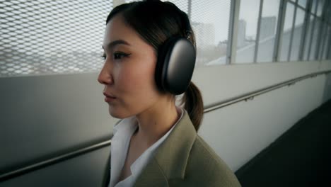 woman walking in urban tunnel with headphones