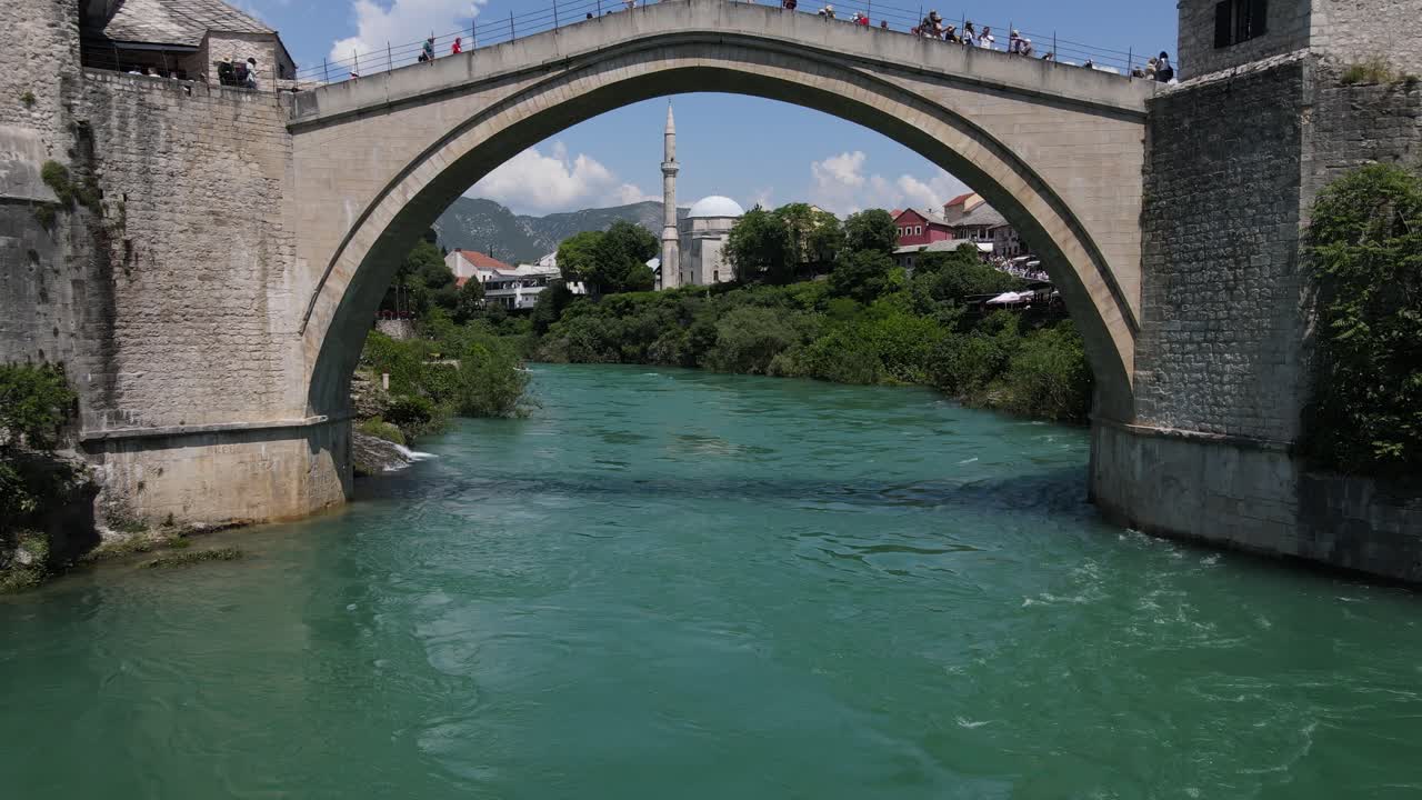 vista aérea del puente histórico de mostar construido sobre el río en la ciudad de bosnia, la gente en el puente turístico