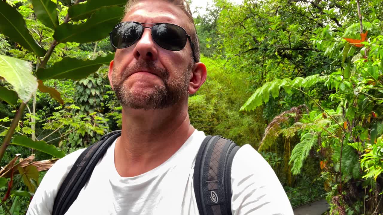 el hombre camina a través de la exuberante jungla verde en hawaii