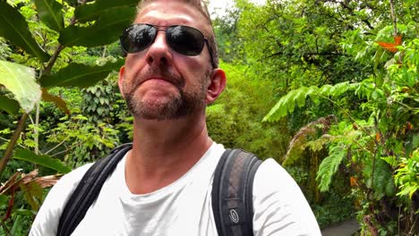 man walks through lush green jungle in hawaii