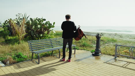 University Student Relaxing On A Bench Near The Ocean