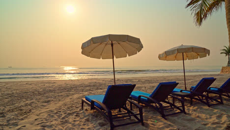 sombrilla de playa con palmeras y playa de mar al amanecer