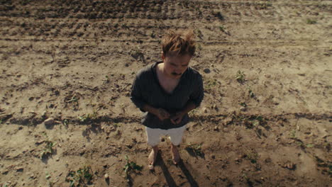 man standing in a rural dirt field