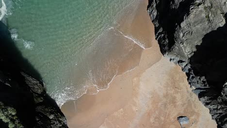 Cala-De-Cornualles-En-Cornualles-Con-Aguas-Turquesas,-Cámara-Lenta-Con-Vista-De-Arriba-Hacia-Abajo-Desde-Drone,-Reino-Unido