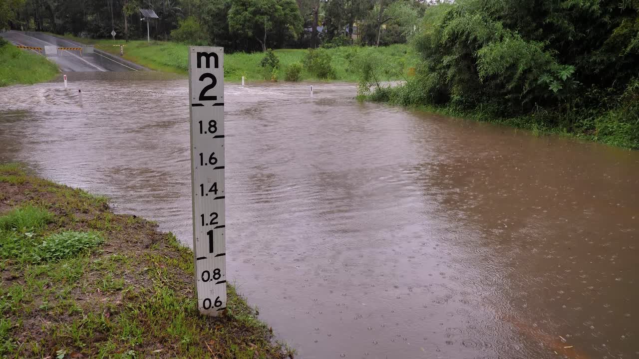 골드코스트, 즐랜드, 2024년 2월 16일 - 강우가 계속되면서 오스트레일리아 남동부 즈랜드의 머지라바에 있는 하디스 로드를 가로지르는 하이트 마커에 홍수가 아졌다.