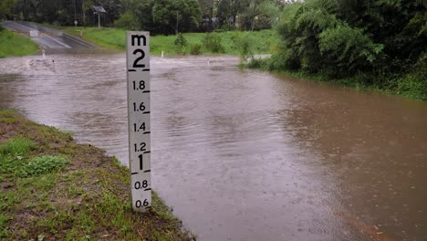 gold coast, queensland, 16 de febrero de 2024 - marca de altura de inundación a través de la carretera de hardy en mudgeeraba después de que las fuertes lluvias continúen azotando el sureste de queensland, australia