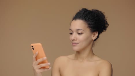 woman smiling while looking at smartphone