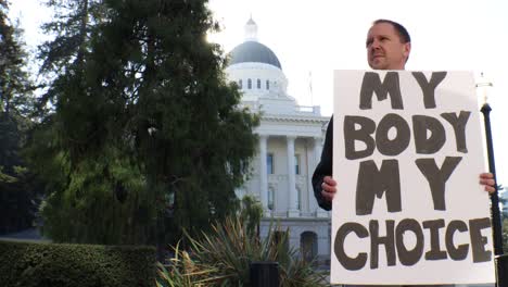 male political protester with my body my choice sign slider dolly tracking shot