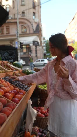 woman shopping for fruit at a street market