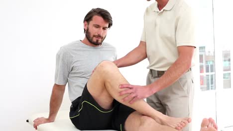 physical therapist checking injured patients knee