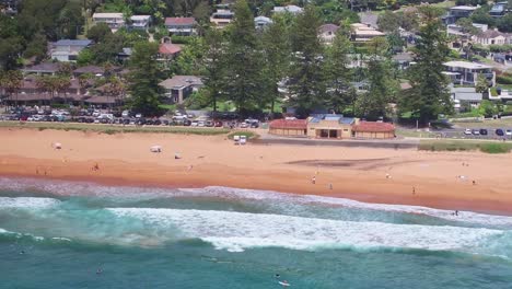 aerial reveal from the sand and life saving area of palm beach to the surfers waiting on the water