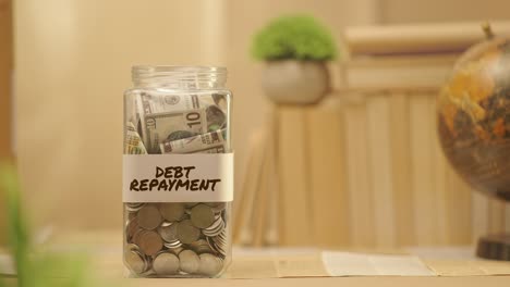 person saving money for debt repayment