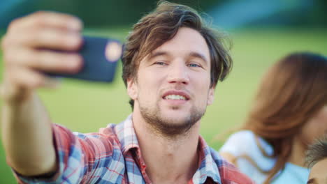 Family-talking-online-on-smartphone-in-meadow.-Family-taking-selfie-on-phone