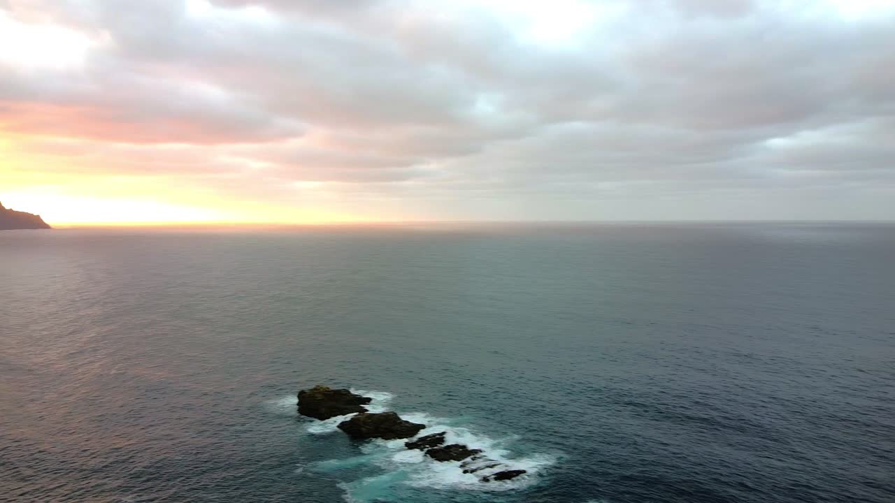 항공 영상. 아침 해가 뜨고 어두워지면. 평온한 푸른 바다. 드론 항공 4k 영상,  ⁇ 이 물결이 바위 위에 부 ⁇ 히고.
