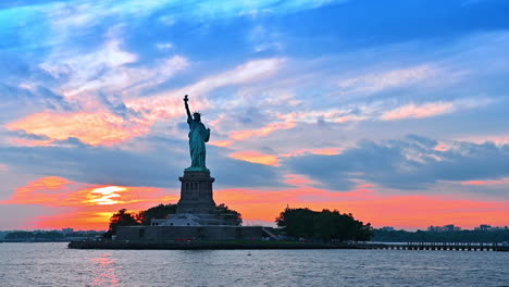 moving on boat along the liberty island. statue of liberty at the backdrop of colorful sky at sunset
