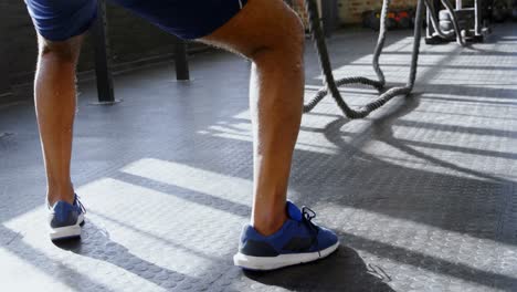 senior man doing crossfit rope training in the fitness studio 4k