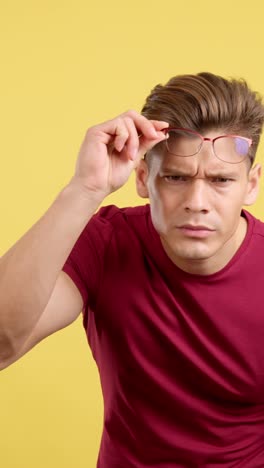 man adjusting his glasses while looking intently