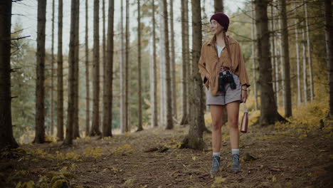 Young-woman-standing-in-forest-during-vacation
