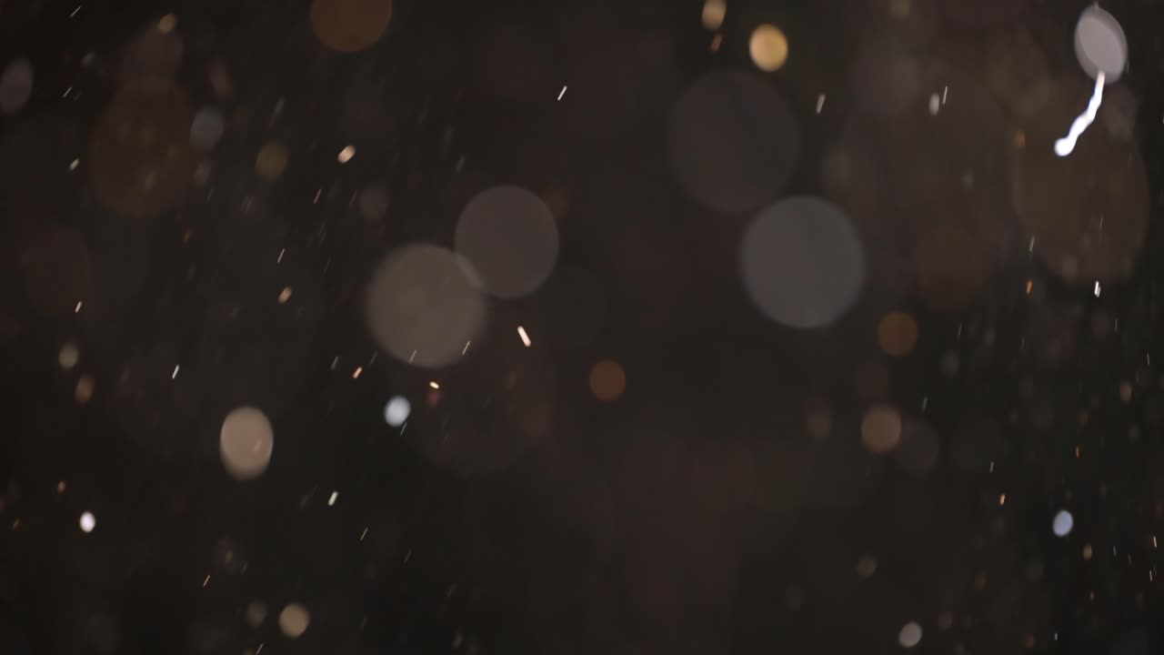Floating abstract particle bokeh on dark background