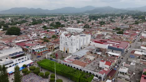 fotografía aérea de la ciudad de tecalitlan con templo blanco y paisaje urbano en méxico - cordillera en el fondo