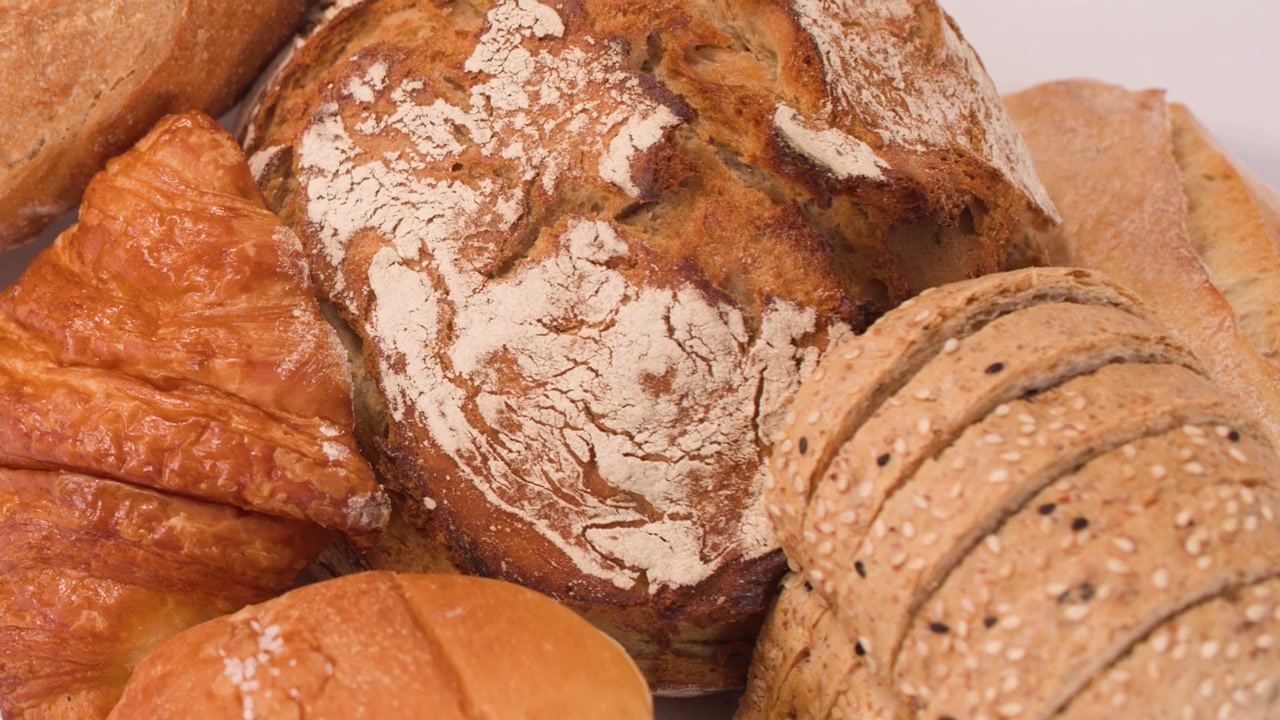 Close-up shot of sourdough, baguettes, and croissants with soft lighting and slow camera movement.