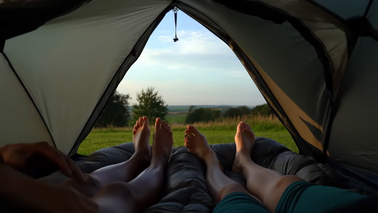 Two people relaxing inside a tent with a scenic view of nature