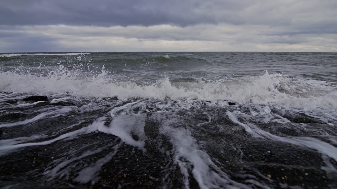 Waves crashing on rocks at the beach in Domburg, Netherlands in super slow motion
