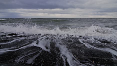waves crashing on rocks at the beach in domburg, netherlands in super slow motion